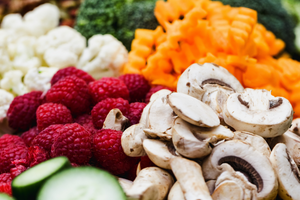 Closeup of raspberries, chopped mushrooms, pumpkin and cauliflower